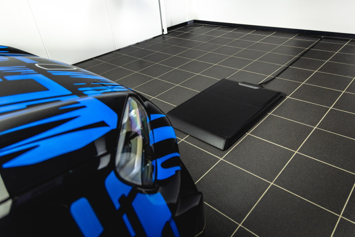 Das Auto rollt über die Ladeeinheit, senkt das Fahrwerk ab und der Ladevorgang mit 11 kW startet automatisch. (Bild: Porsche)